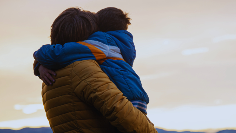 En man håller en pojke i famnen